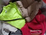 a pile of clothes that is sitting on a bed