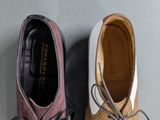 two pairs of shoes are lined up on a gray surface