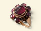 an image of a close up of a ring with a red stone