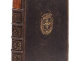 un vieux livre orné d'un emblème doré sur la couverture