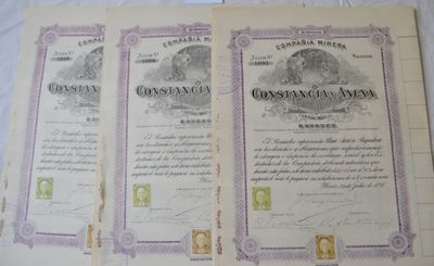 two old certificates are sitting on a white sheet on a table