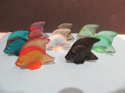 five fish figurines sitting on a white surface