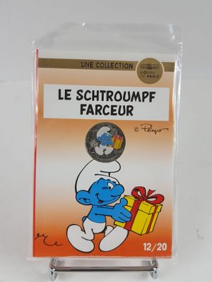 the smurch is holding a present in a clear box