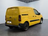 yellow citrole van parked in a large room with a white wall
