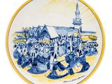 une image représentant une assiette bleue et blanche ornée d'une illustration d'une église