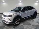un 4x4 blanc garé sur un sol en damier dans un garage