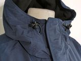 the back of a blue jacket with a hood and zippers on it