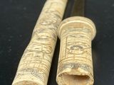 paire de porte-pipes égyptiens antiques en bois sculpté, posés sur un fond noir