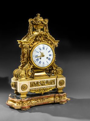 une horloge en or posée sur un socle en bois