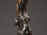 a bronze statue of a man holding a dog on a pedestal