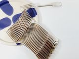 a white plate with forks and a blue plate with spoons on it