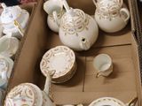a lot of tea pots and cups sitting in a box