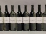 six bouteilles de vin sont alignées sur une table