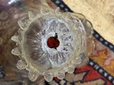 un vase en verre posé sur un tapis, à même le sol