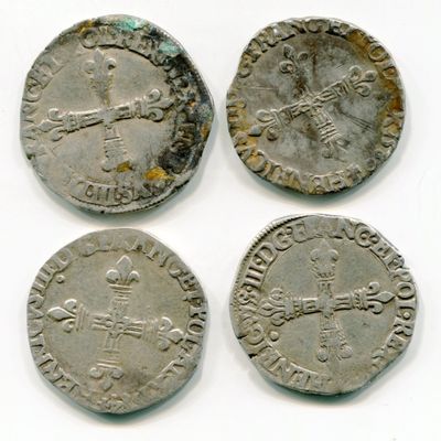 quatre pièces d'argent de tailles et de formes variées sur un fond blanc