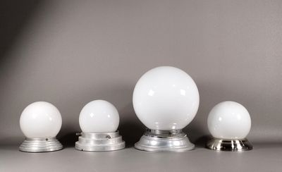 trois boules de verre blanches posées les unes à côté des autres sur une table