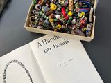 une boîte de perles et un livre posés sur une table