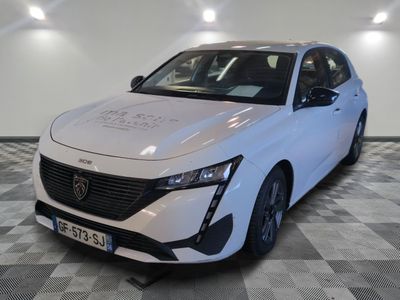 la voiture blanche est garée sur un sol en damier dans le garage