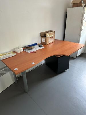 une photo d'un bureau dans une pièce où se trouve un réfrigérateur
