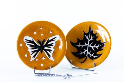 deux assiettes jaunes ornées de motifs en noir et blanc