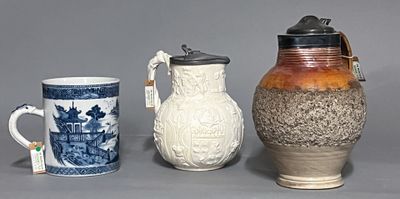 trois vases et une tasse posés les uns à côté des autres sur une table