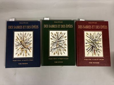 trois livres posés sur une table blanche, avec une couverture noire et rouge