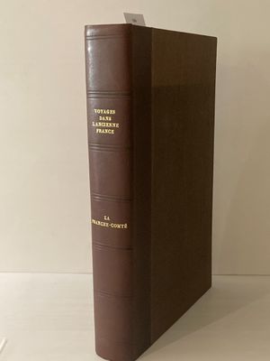 un vieux livre posé sur une table à côté d'un mur blanc