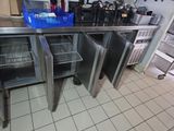 une cuisine avec des placards en inox et une poubelle bleue