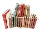 several old books are stacked on top of each other on a white surface
