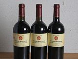 three bottles of wine sitting on a wooden table next to a bottle of wine