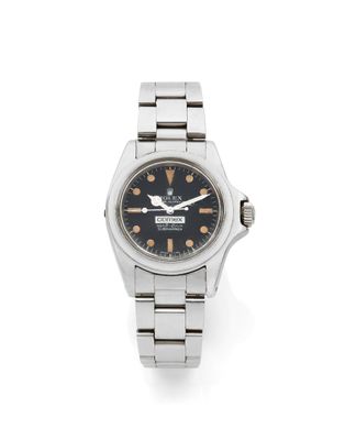 un gros plan d'une montre sur une surface blanche avec un fond blanc