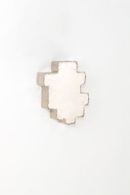 un morceau de papier sur lequel une croix a été découpée, posé sur une surface blanche