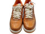 a pair of brown sneakers with white laces on them
