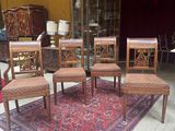 six chairs and a table in a room with a rug on the floor