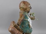 statue of a boy with a suitcase and a flower in his hand