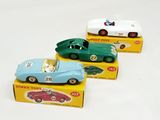 three toy cars that are sitting on a white surface