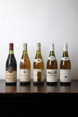 several bottles of wine are lined up on a wooden table