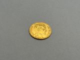 a close up of a gold coin on a gray surface