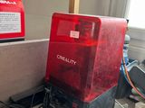 une boîte rouge posée par terre à côté d'une boîte noire