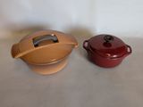 pair of red and brown casserole pots on a table