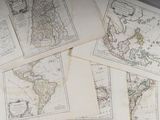 Plusieurs anciennes cartes du monde sont posées sur une table