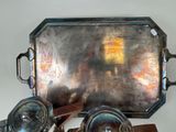 a silver tray with a mirror on it next to a pair of silver spoons