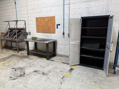 a refrigerator and a table in a room with a wall