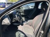 the interior of a car with the door open and the driver ' s seat down