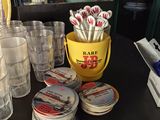 de nombreuses tasses et verres posés sur une table, à côté d'un seau jaune