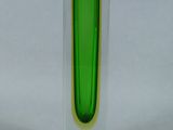 a green vase that is sitting on a white surface