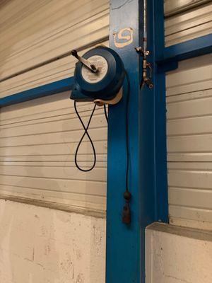 un poteau bleu sur lequel est fixée une horloge, dans un garage