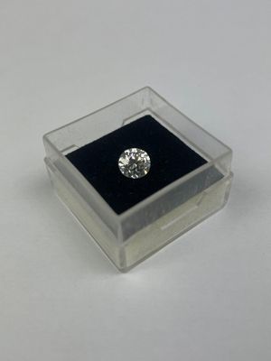 un diamant dans une boîte transparente posée sur une surface blanche