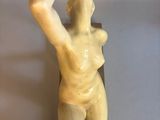statue of a woman holding a ball in her right hand