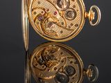 an image of a close up of a pocket watch on a reflective surface
